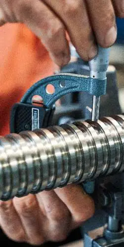 Technician inspecting spline shaft diameter with a micrometer at United Broach Company